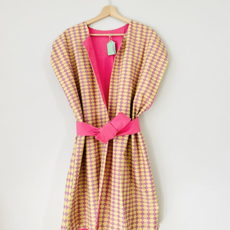 Front view of pink and mustard reversible vest in structured cotton