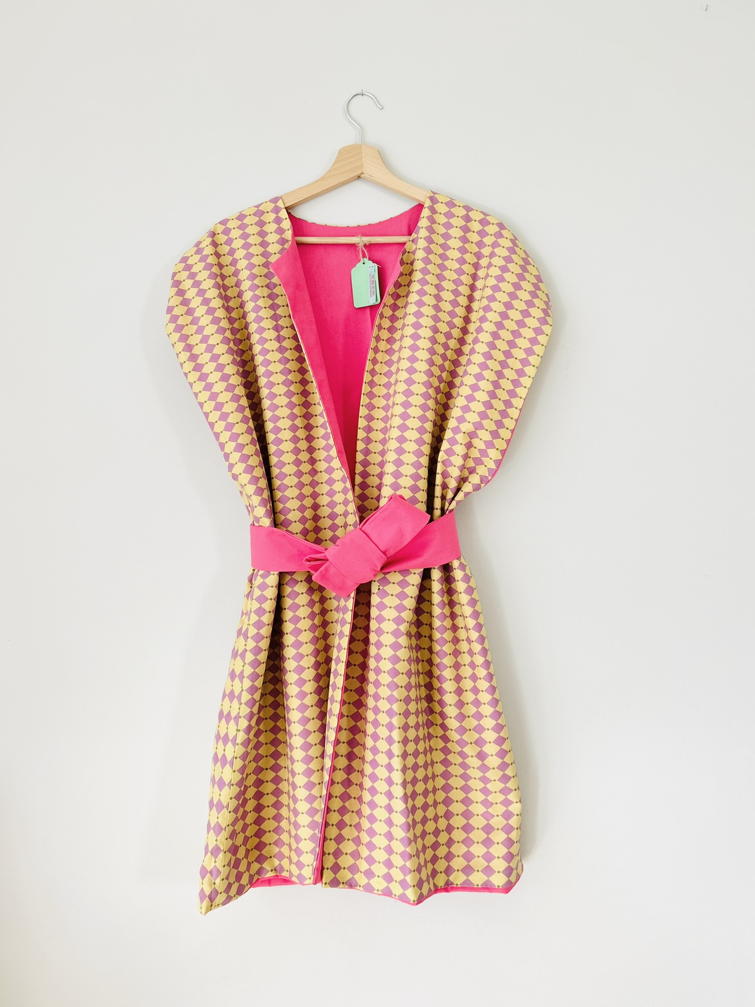 Front view of pink and mustard reversible vest in structured cotton