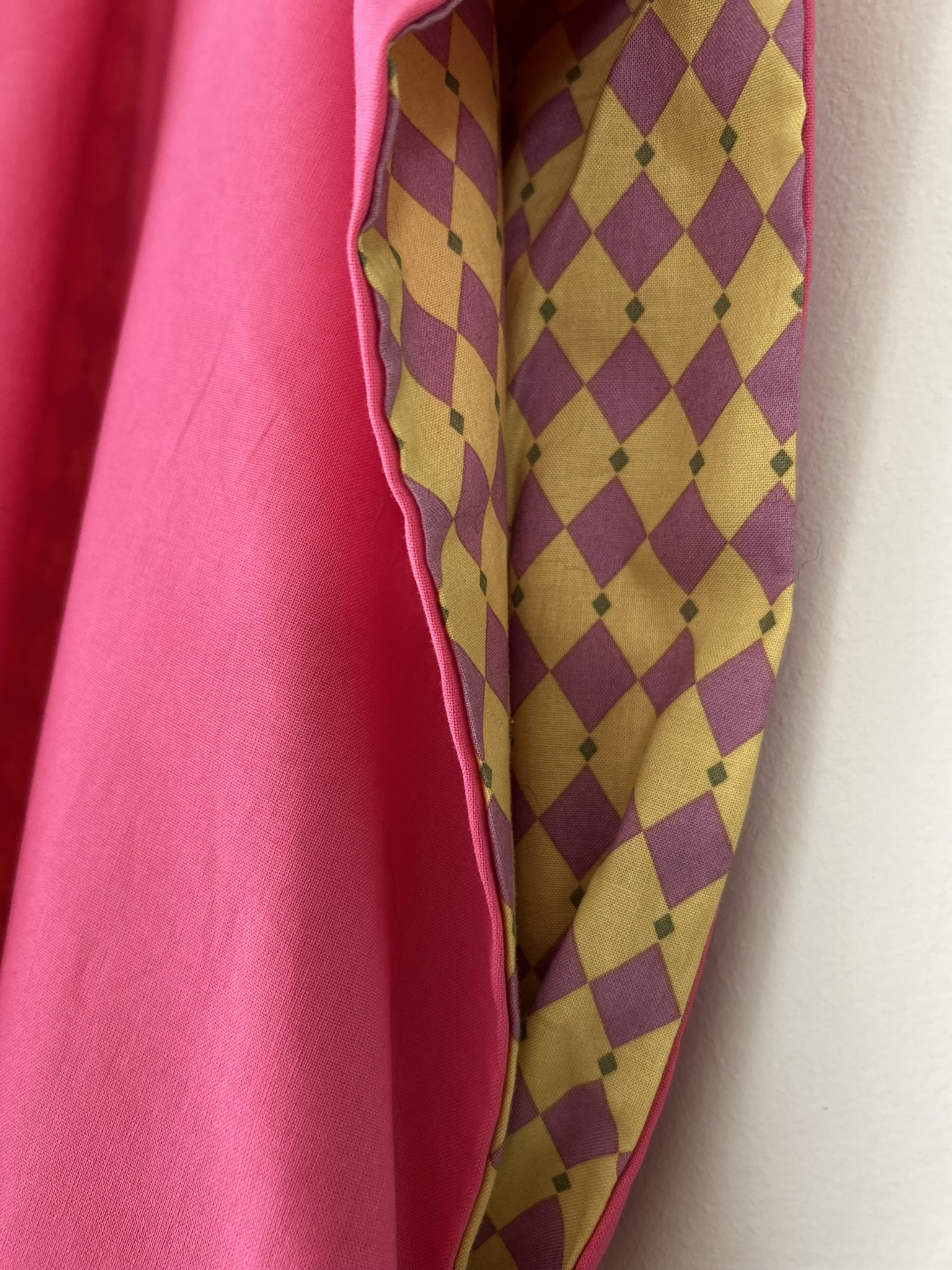 Close up detail of pink mustard cotton vest fabric and stitching